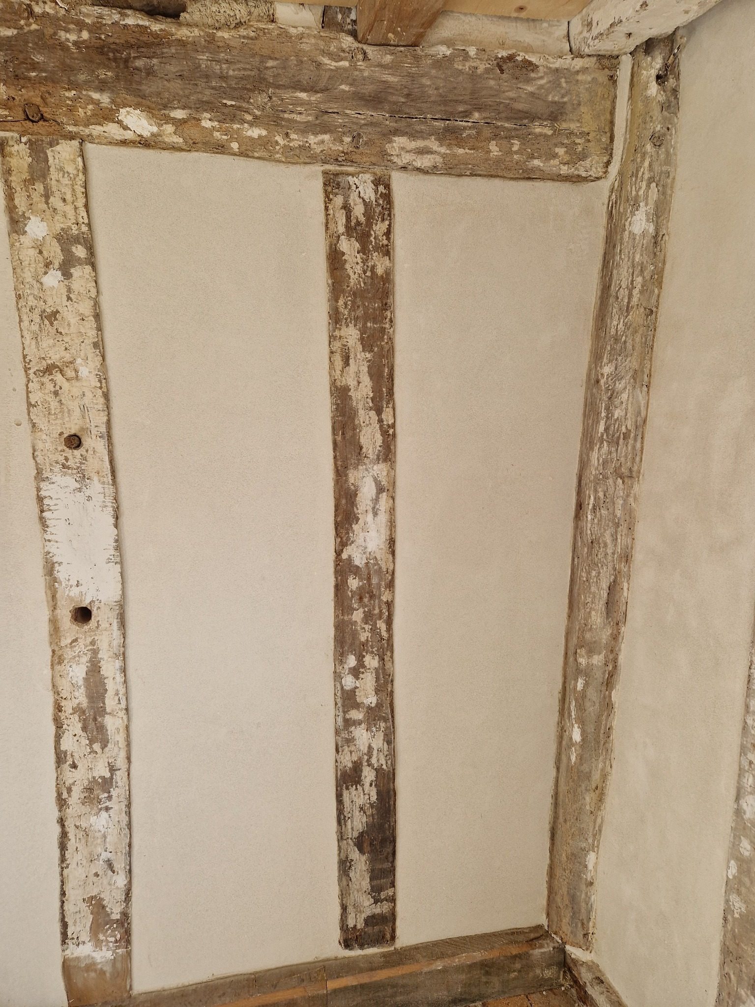 Finished lime plaster between original timber framing
